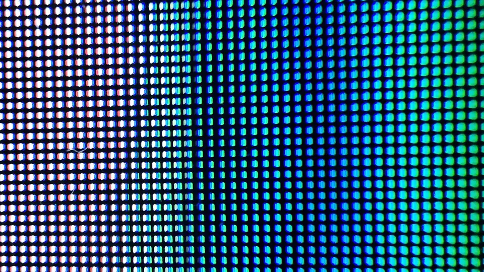 Nærbilde av lysende piksler i rødt, hvitt, blått og grønt på en OLED-TV-skjerm