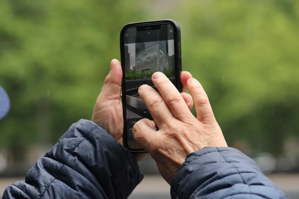 To hender holder en mobiltelefon utendørs